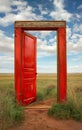 An open red door in an overgrown meadow