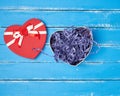 open red heart-shaped gift box with a bow on a blue wooden background Royalty Free Stock Photo