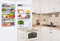 Open refrigerator filled with fresh fruits, vegetables and milk