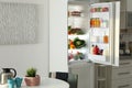Open refrigerator full of products in stylish interior Royalty Free Stock Photo
