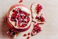 Ripe pomegranate seeds top view. Fresh red garnet on wooden background. Flat lay. Open fruit on cutting board