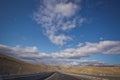 Asphalt road and bright blue sky with fluffy clouds . Empty desert asphalt road from low angle with mountains and clouds on Royalty Free Stock Photo