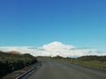 Open road with wide expanse of blue sky above with white clouds. The open road. Cycling tour. Royalty Free Stock Photo