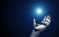 open robotic hand holds a point of light on blue background