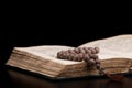 Open sacred book for prayer and wooden rosary Royalty Free Stock Photo