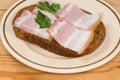 Open sandwich with boiled-smoked pork belly slices on saucer