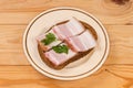Open sandwich with boiled-smoked pork belly slices on saucer