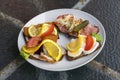 Open sandwiches bread with different kind of cold cuts on a plate standing on a rusty table Royalty Free Stock Photo