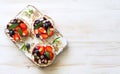 Open sandwiches with cream cheese, strawberries, blueberries, jam and almond flakes