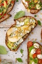Open sandwiches, in the middle of board an open avocado sandwich made of slice of sourdough bread with the addition of pear, blue