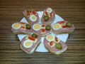Open sandwiches on plate with salad, salami, egg, cheese, pepper and cucumber
