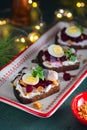 Open sandwiches smorrebroda on rye bread with marinated beetroot, cream cheese, herring and quail egg in Christmas style on a Royalty Free Stock Photo