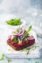 Open sanwich with dark rye bread, beet, marinated herring, pickled cucumber and red onion, smorrebrod