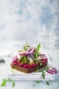 Open sanwich with dark rye bread, beet, marinated herring, pickled cucumber and red onion, smorrebrod