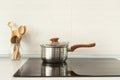 Open saucepan and wooden spoons in modern kitchen with induction stove. Royalty Free Stock Photo