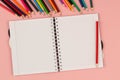 Open school squared notebook and pencils on the pink background. Top view Royalty Free Stock Photo