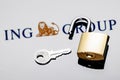 An open security lock and key on background of ING Group logo in mirror reflection