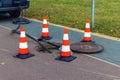 Open sewer manhole on the street with warning cones Royalty Free Stock Photo