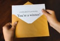 An open shiny gold envelope with a letter that says Congratulations You`re a winner! Royalty Free Stock Photo