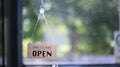 Open sign board hanging on glass door of coffee shop. Royalty Free Stock Photo