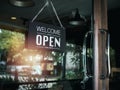 Open sign board with white text on black vintage wooden sign `Welcome we are open please come in`. Royalty Free Stock Photo