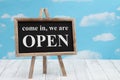 Open sign on standing chalkboard with sky