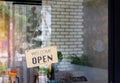 Open sign wooden broad through the glass of window at coffee shop Royalty Free Stock Photo