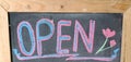 open sign written in colorful chalk on a wooden board Royalty Free Stock Photo