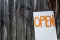 Open sign written in orange with a wooden fence in the background Royalty Free Stock Photo