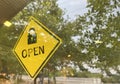 Open sign yellow board hanging on the coffee cafe shop door for welcome. Royalty Free Stock Photo