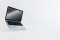 Open silver laptop floating on white background, technology and design concept.