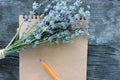 Open sketchbook with blank brown paper and a bunch of lavender flowers on rustic gray wooden background with copy space. Royalty Free Stock Photo