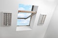 Open skylight roof window on slanted ceiling in attic room, bottom view Royalty Free Stock Photo