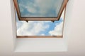 Open skylight roof window on slanted ceiling in attic room, bottom view Royalty Free Stock Photo