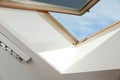 Open skylight roof window on slanted ceiling in attic room, low angle view Royalty Free Stock Photo