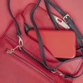 Open small leather handbag with black strap and red mobile phone, top view Royalty Free Stock Photo