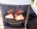 Open smoker with fresh fillet of salmon being cooked in close up