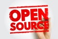 OPEN SOURCE text displayed in bold red stamp lettering with a hand marking the words, illustrating collaborative coding, free Royalty Free Stock Photo