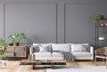 Open space living room interior mockup, white sofa, rattan chair, lots of fresh plants and wooden coffee on empty gray wall Royalty Free Stock Photo