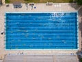 The open sports swimming pool glistened under the bright sun as people swimming in its inviting waters.