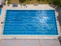 The open sports swimming pool glistened under the bright sun as people swimming in its inviting waters.