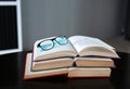 Open stack hardback books with glasses on wooden table. Education background