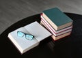 Open stack hardback books with glasses on wooden table. Education background