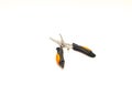 Open black stainless steel fishing pliers with orange rubber handgrip isolated on white