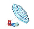 Open striped beach umbrella, towel, flip flops and hat on white background Royalty Free Stock Photo