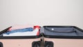 Open suitcase with folded clothes and blank background space Royalty Free Stock Photo