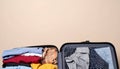 Open suitcase with folded clothes and blank background space Royalty Free Stock Photo