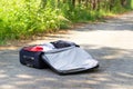 An open suitcase with things lies on a forest road against a background of green foliage on a summer sunny day Royalty Free Stock Photo