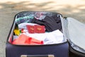 An open suitcase with things and two passports lies on the road on a sunny summer day Royalty Free Stock Photo