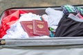 An open suitcase with things and two passports lies on the road on a sunny summer day Royalty Free Stock Photo